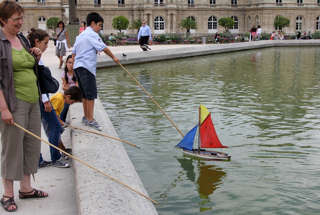 People Steering Boat with Sticks